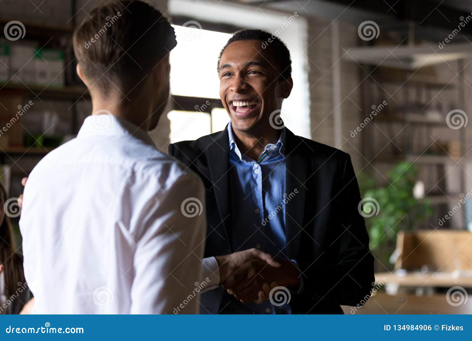 happy black ceo handshaking rewarding successful worker, employe