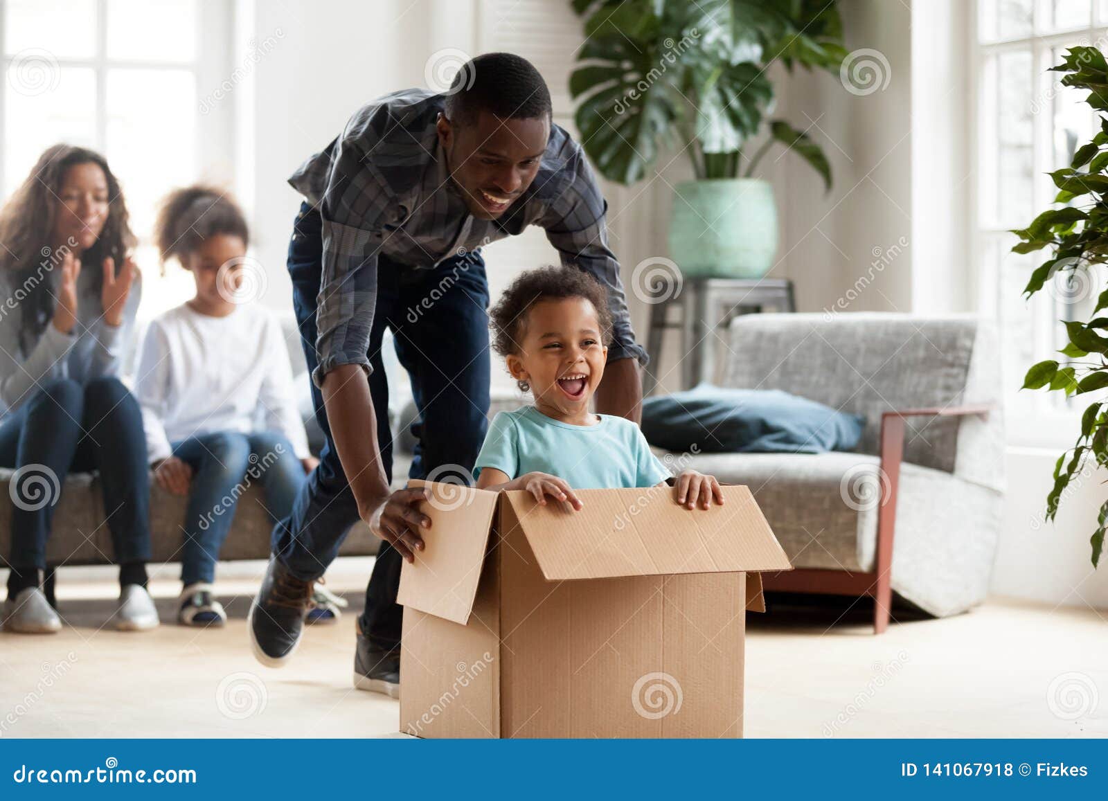 happy black family play with kids moving to new home