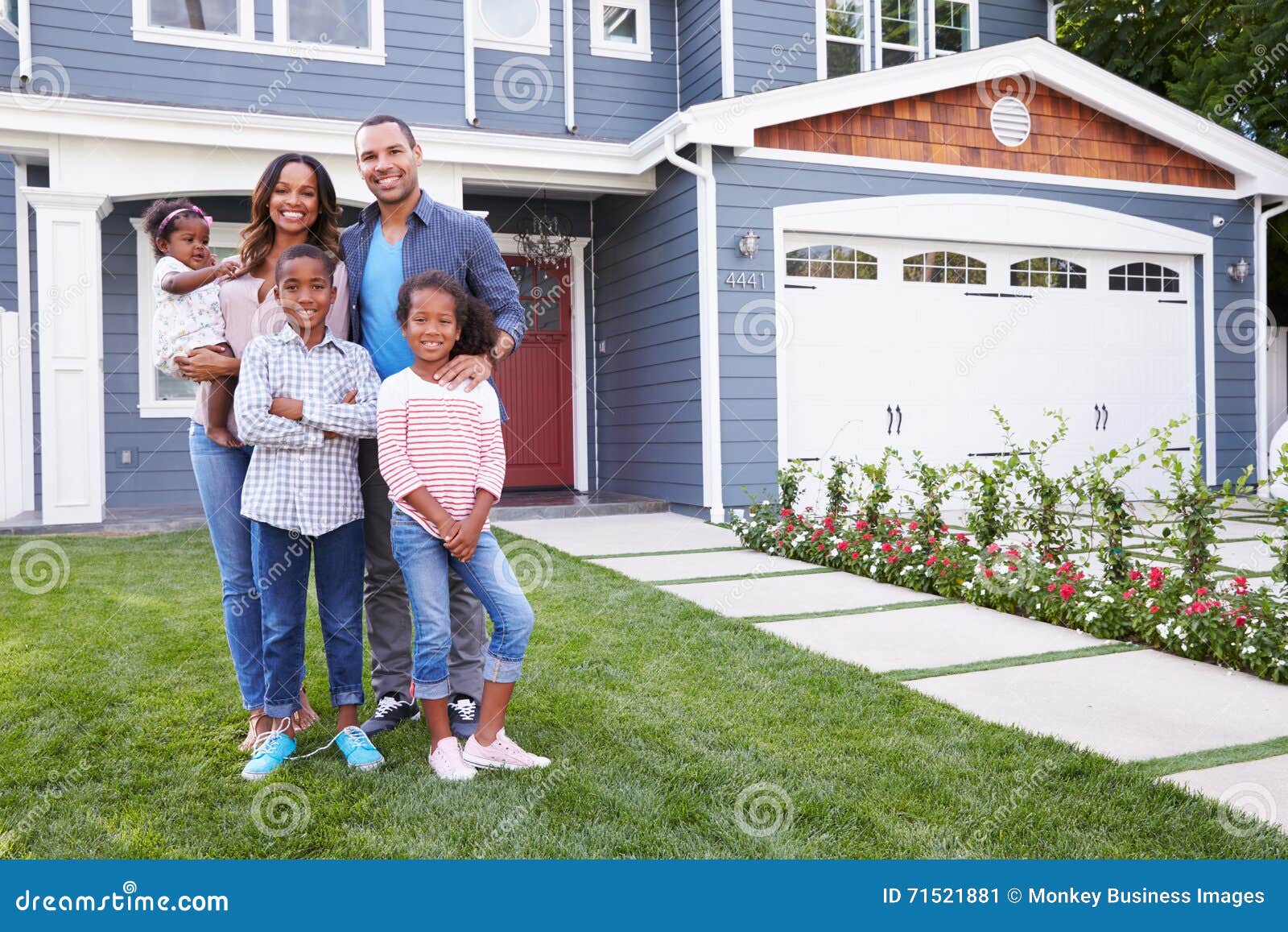 happy black family standing outside their house