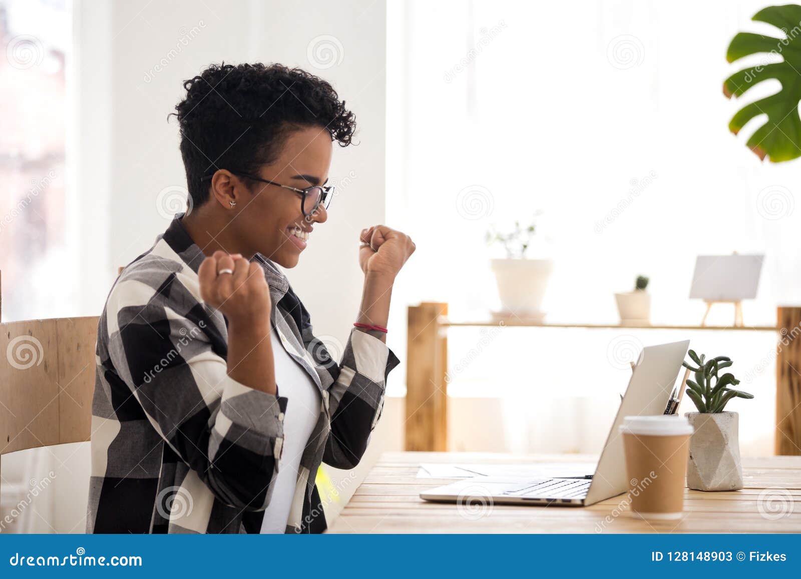 excited woman feels happy sitting at the desk indoors