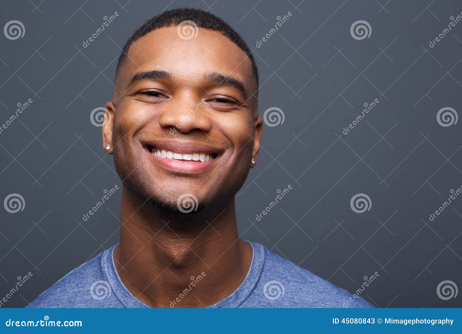 happy black man smiling on gray background