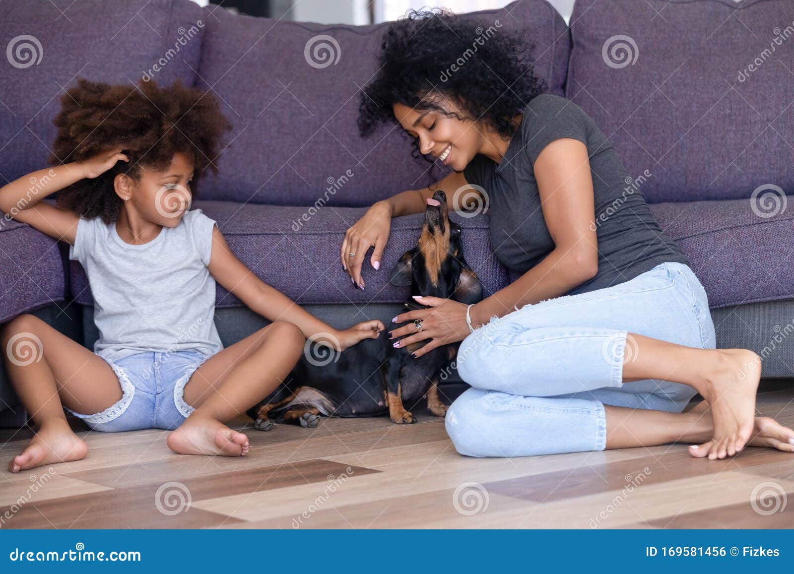 happy black mom and daughter relax having fun with dog