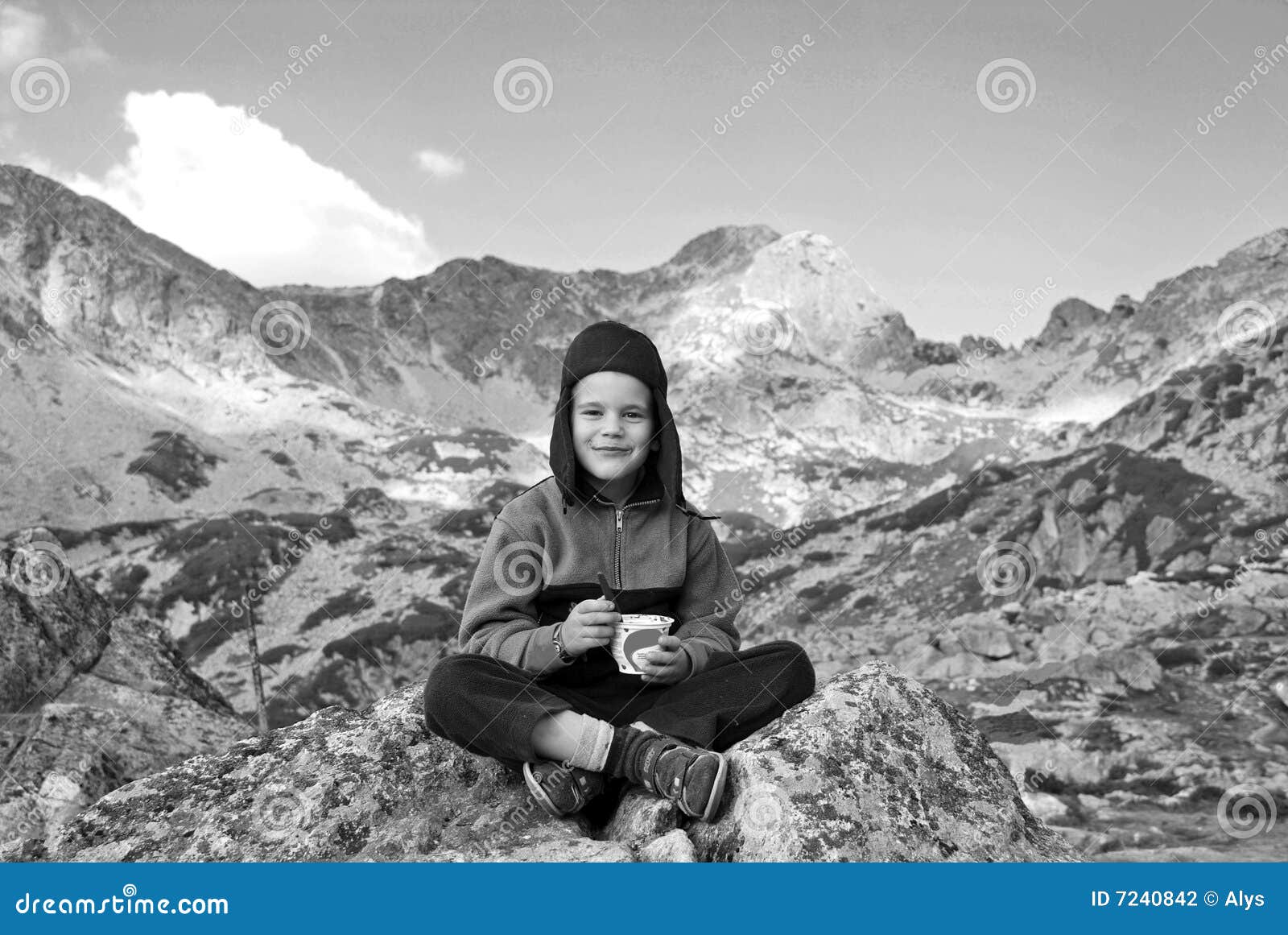 A portrait with happy boy eating chocolate on the mountain