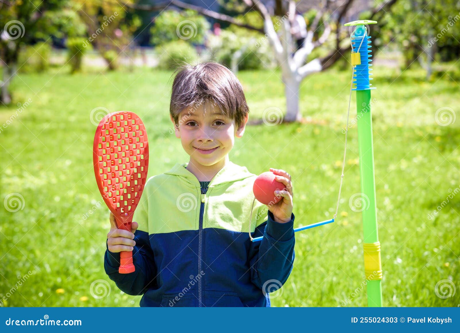 happy boy is playing tetherball swing ball game in summer campin