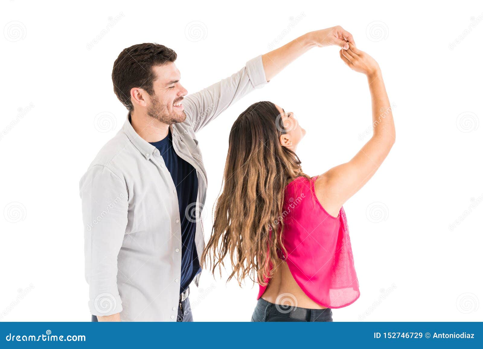 Young Man Spinning Woman Against White Background Stock Image