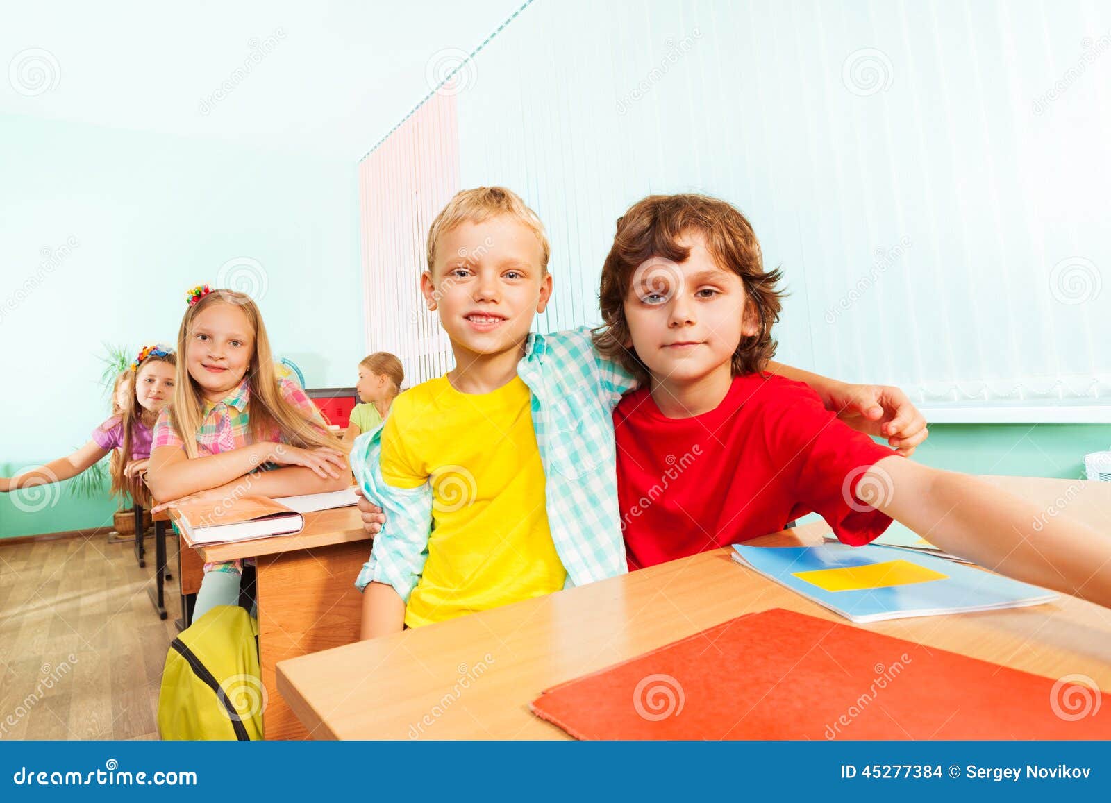 happy boys cuddle and sit together in school