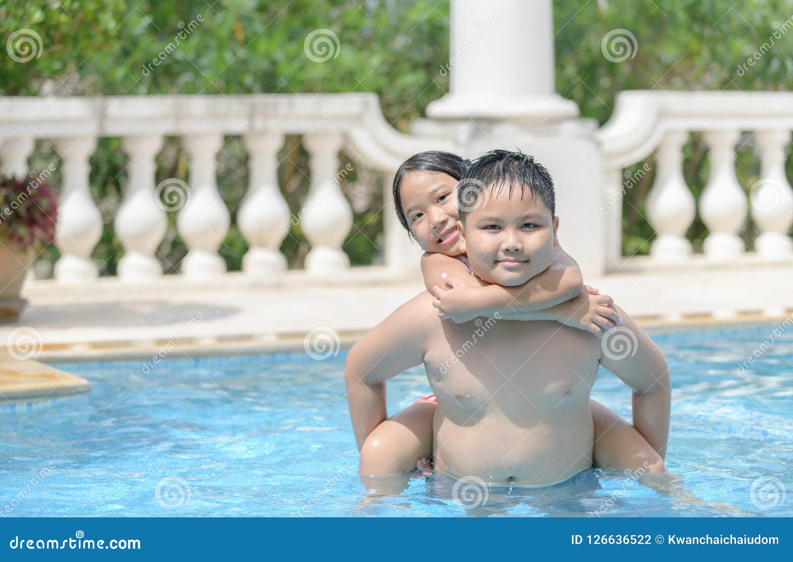 Brother And Sister Playing In Outdoors Swimming Pool Stock 