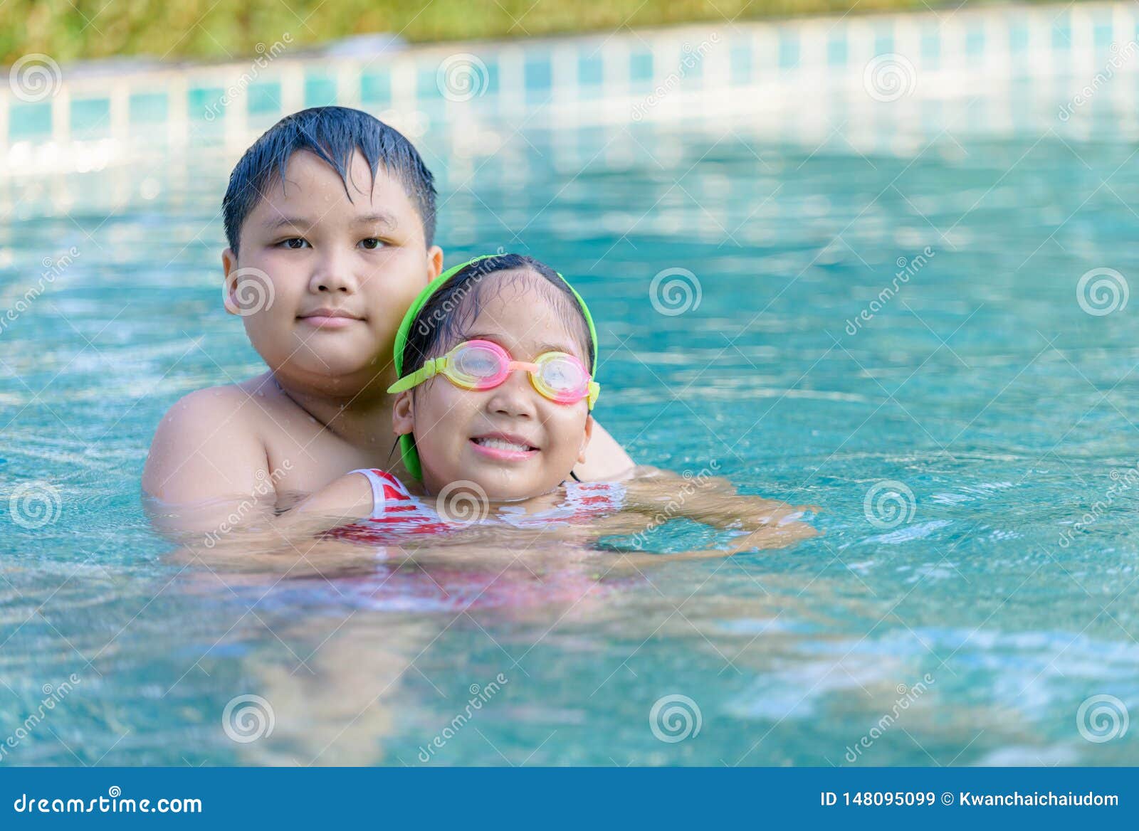 Young Brother And Little Sister Smiling At Swimming Pool 