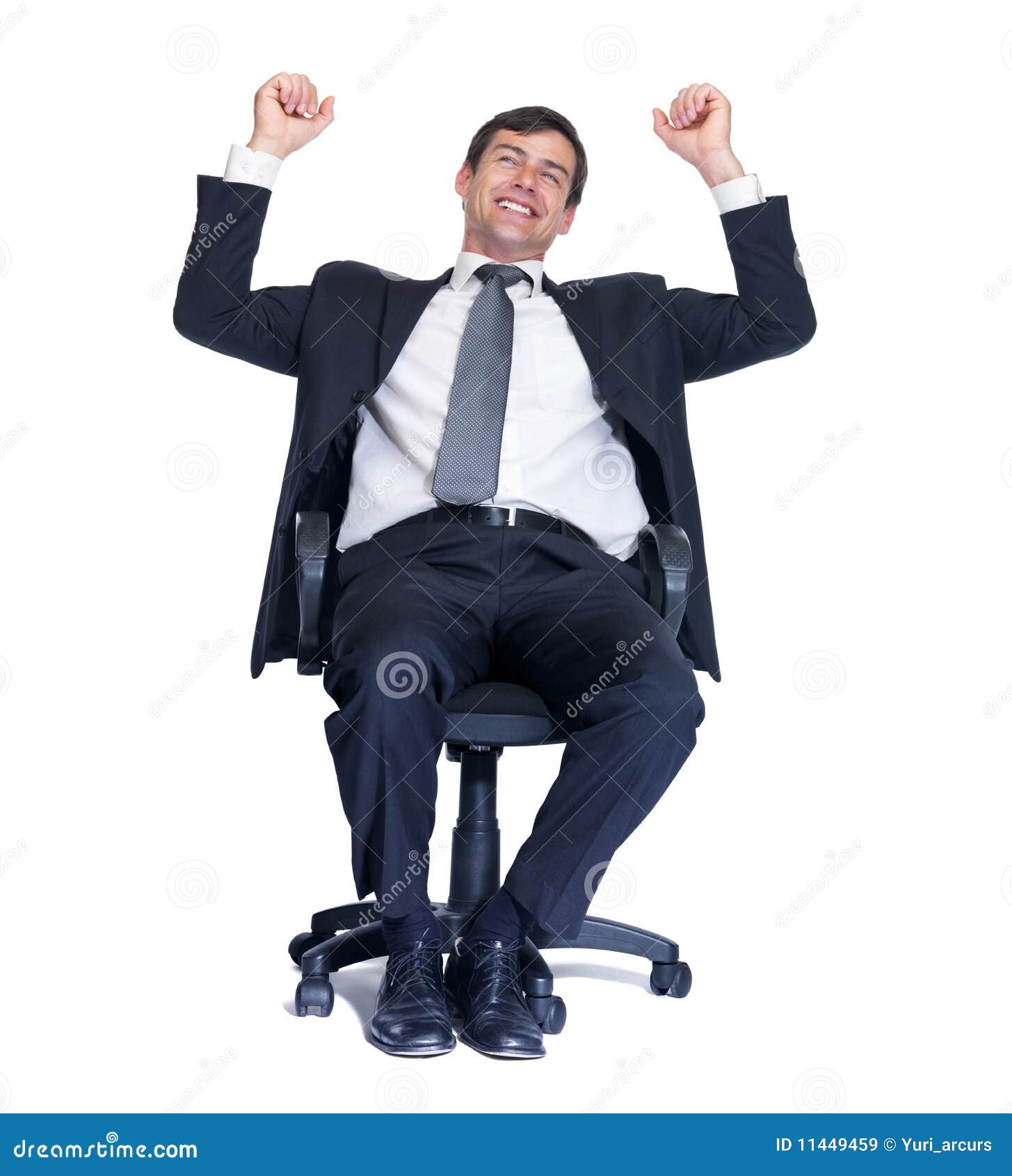 Happy business man sitting on a chair. Successful middle aged business man with clenched fist sitting isolated on a chair over white