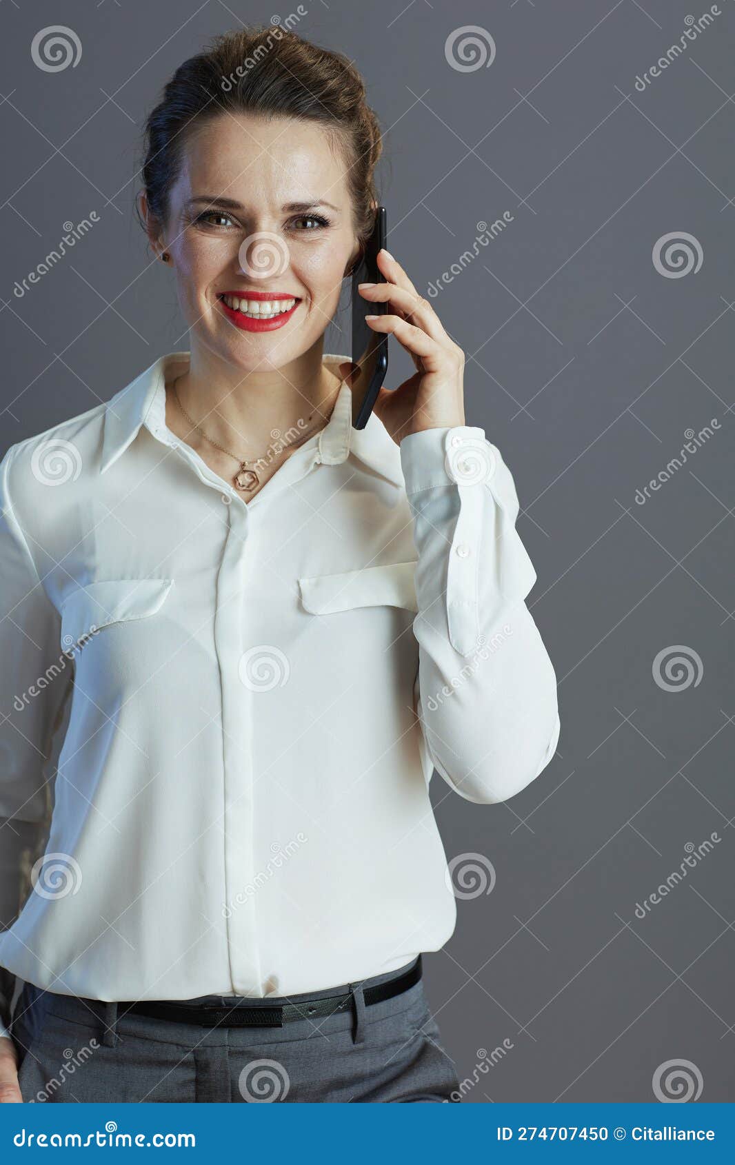Happy Business Owner Woman Using Mobile Phone Isolated on Grey Stock