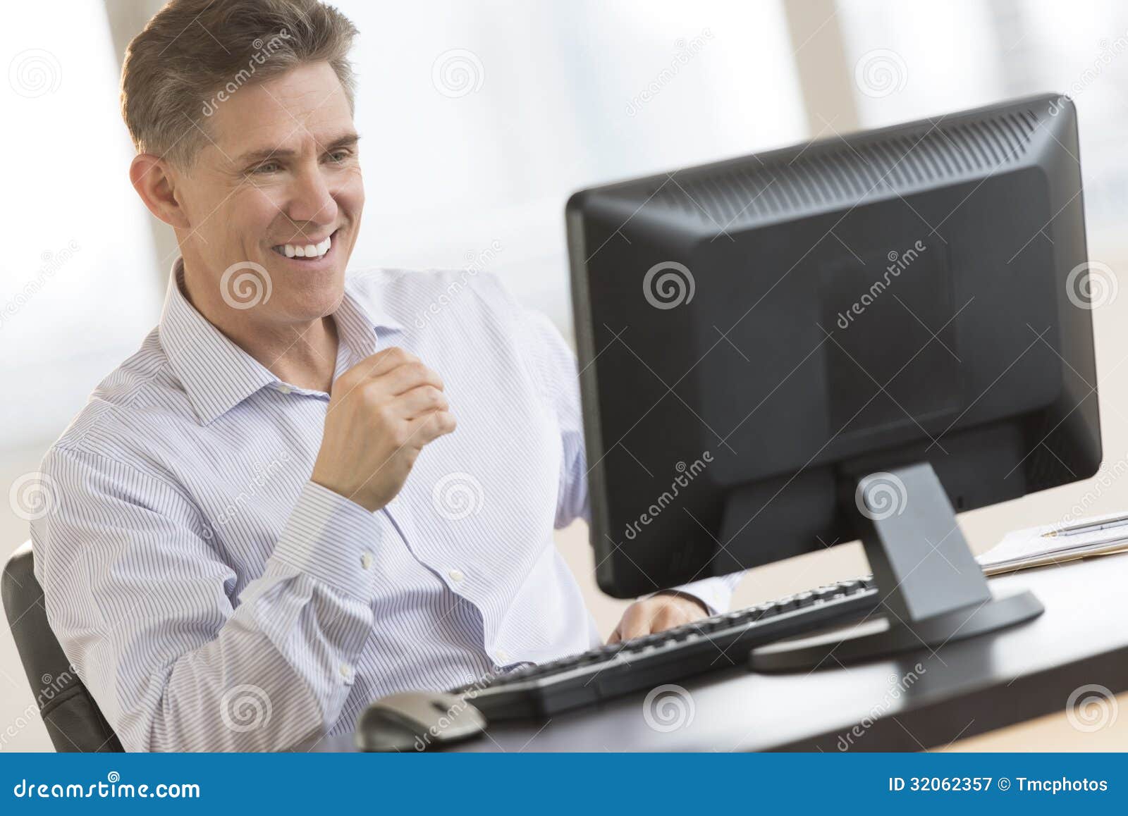 happy businessman looking at computer monitor