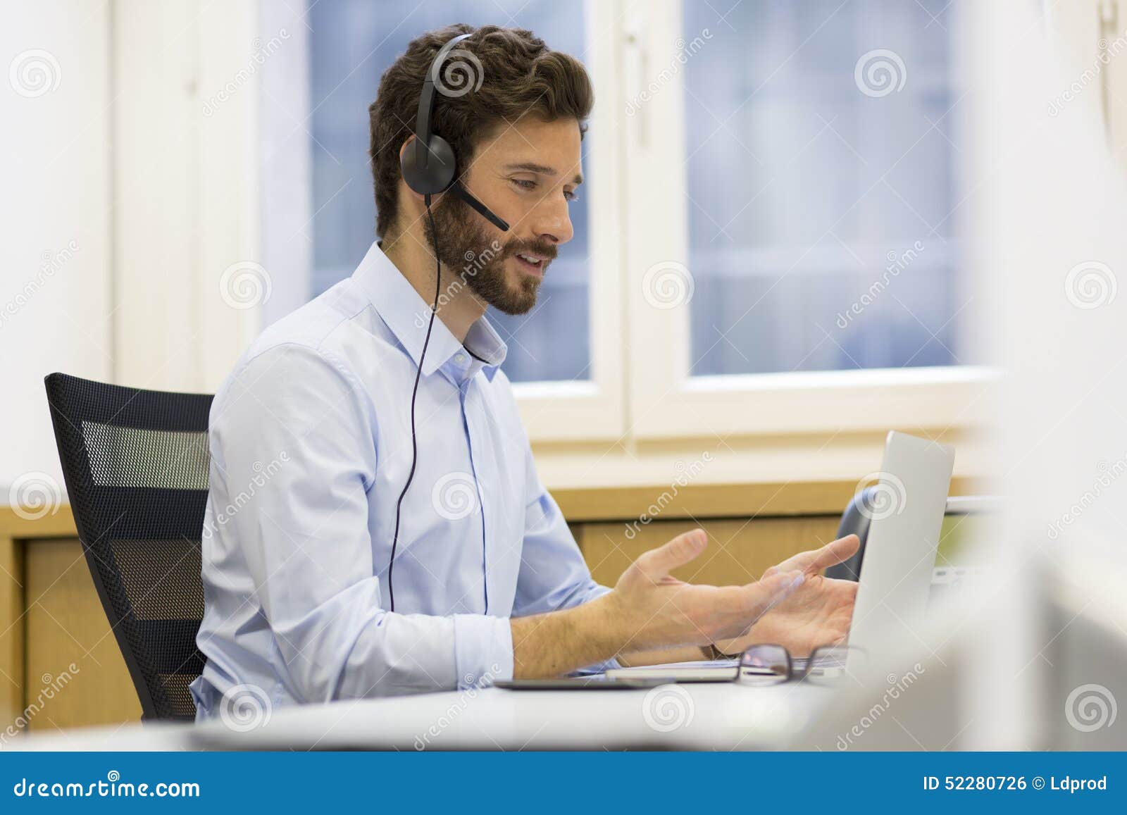 happy businessman in the office on the phone, headset, skype