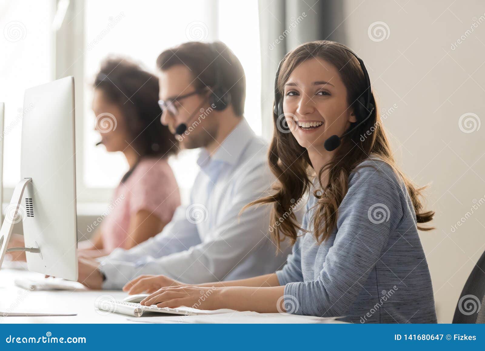 happy businesswoman call center agent looking at camera at workplace