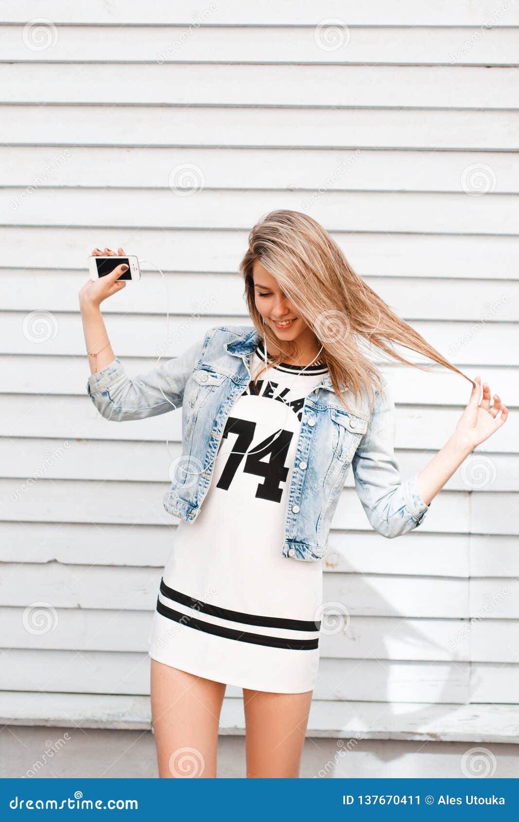 Happy Charming Young Woman in a Sporty White Dress in a Stylish Denim ...