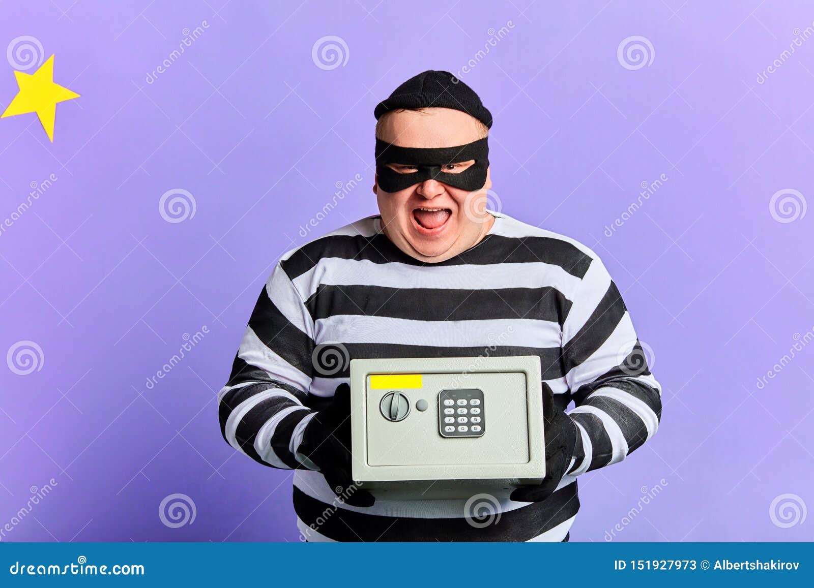 Happy Cheerful Excited Burglar In Mask And Striped Clothes Holding Safety Box Stock Image