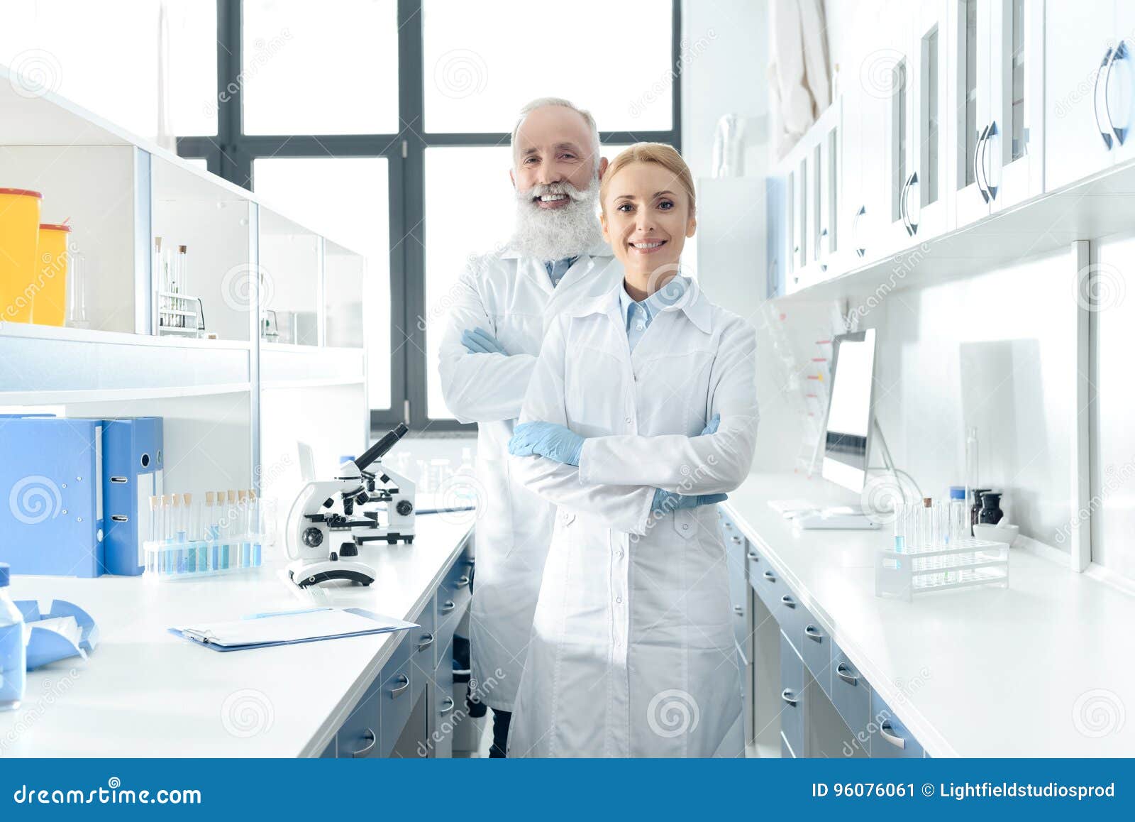 Happy Chemists in White Coats Standing in Chemical Laboratory with