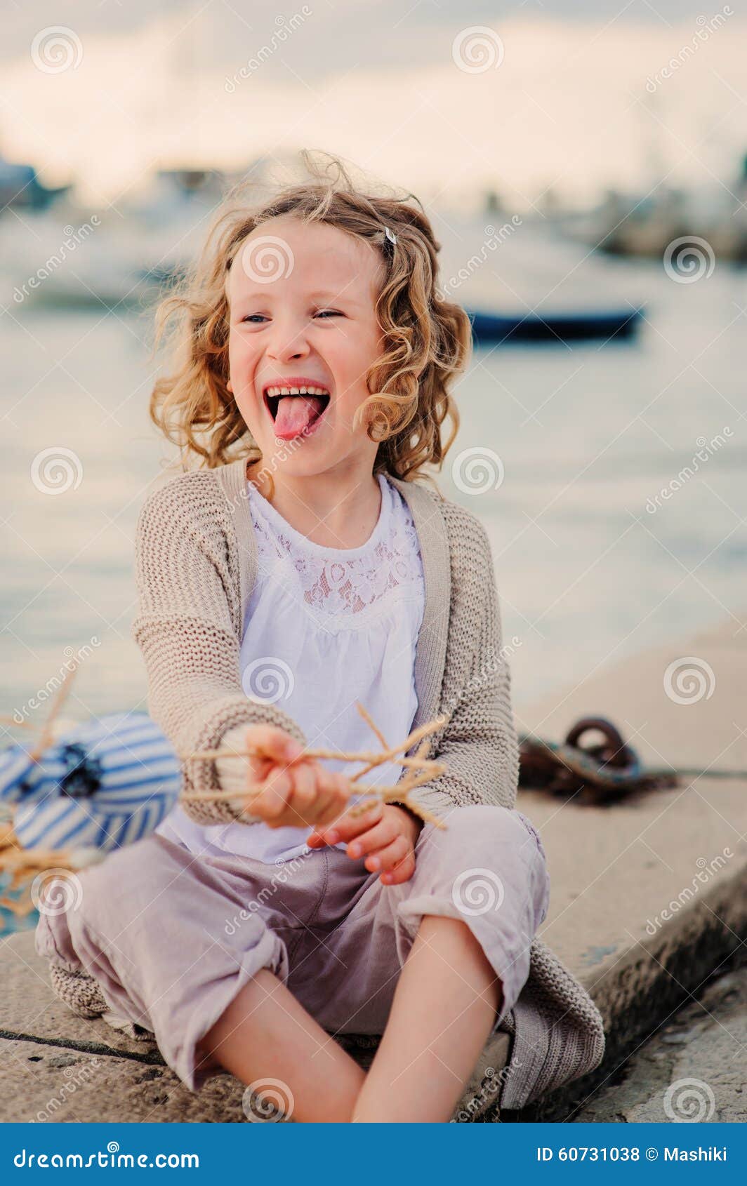 Happy child girl fooling and playing with toy bird on summer seacost. Happy child girl fooling and playing with toy bird on summer seacoast, summer vacation concept