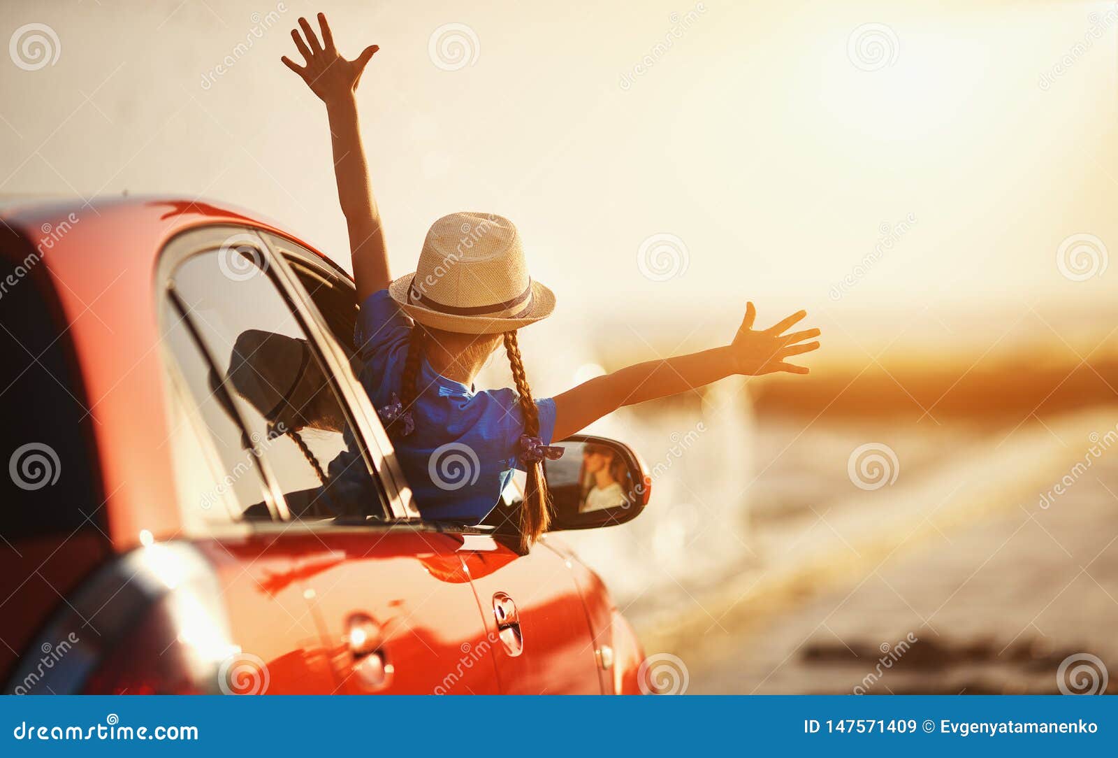happy child girl goes to summer travel trip in car