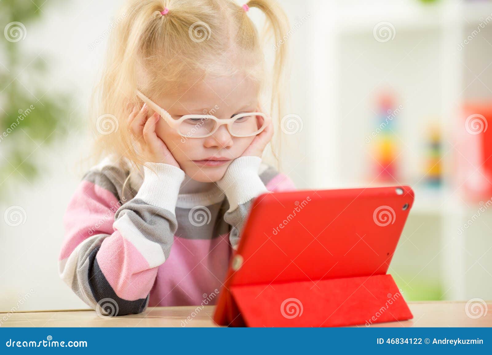 happy child in glasses looking at mini tablet pc