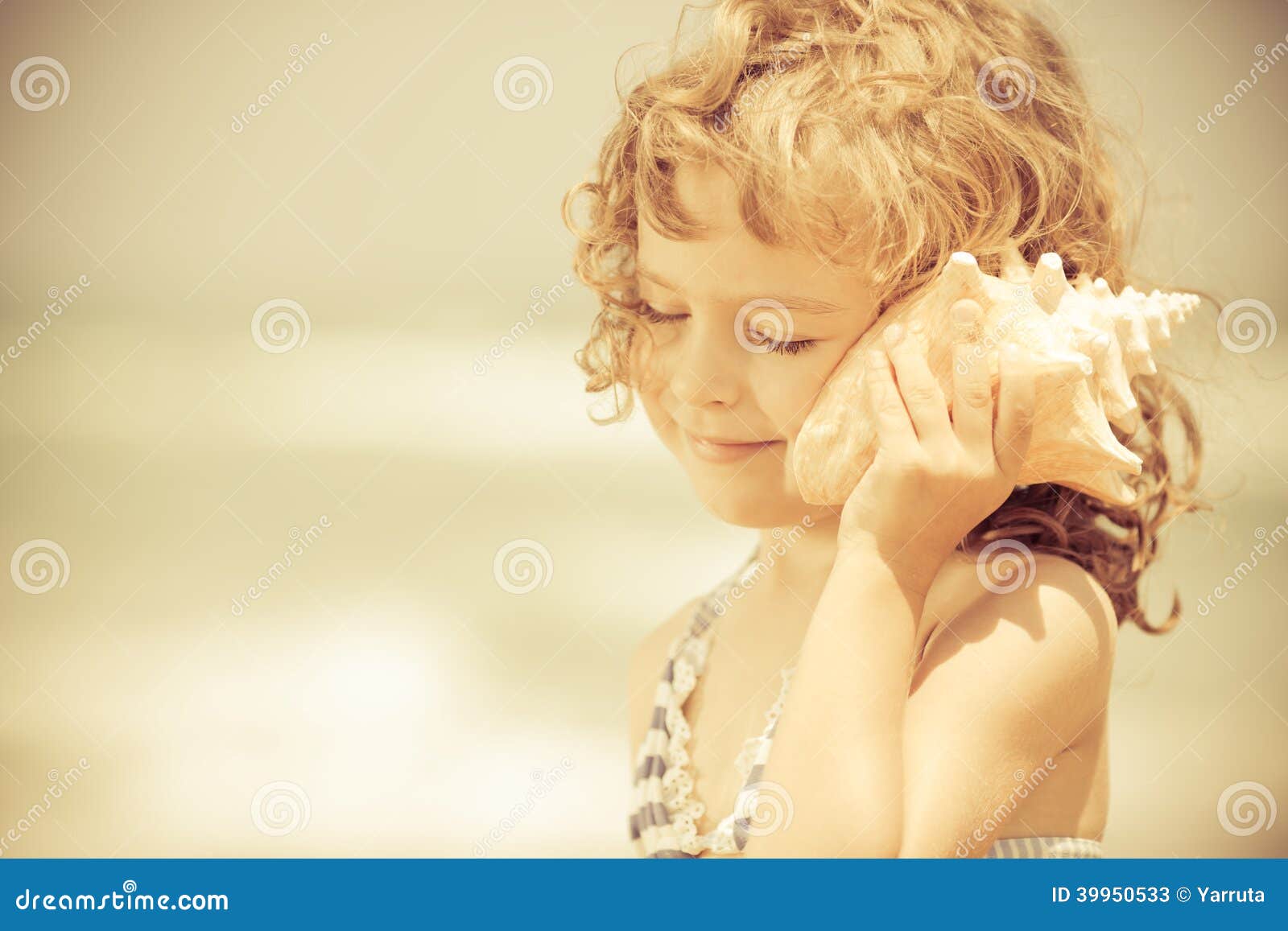 happy child listen to seashell at the beach