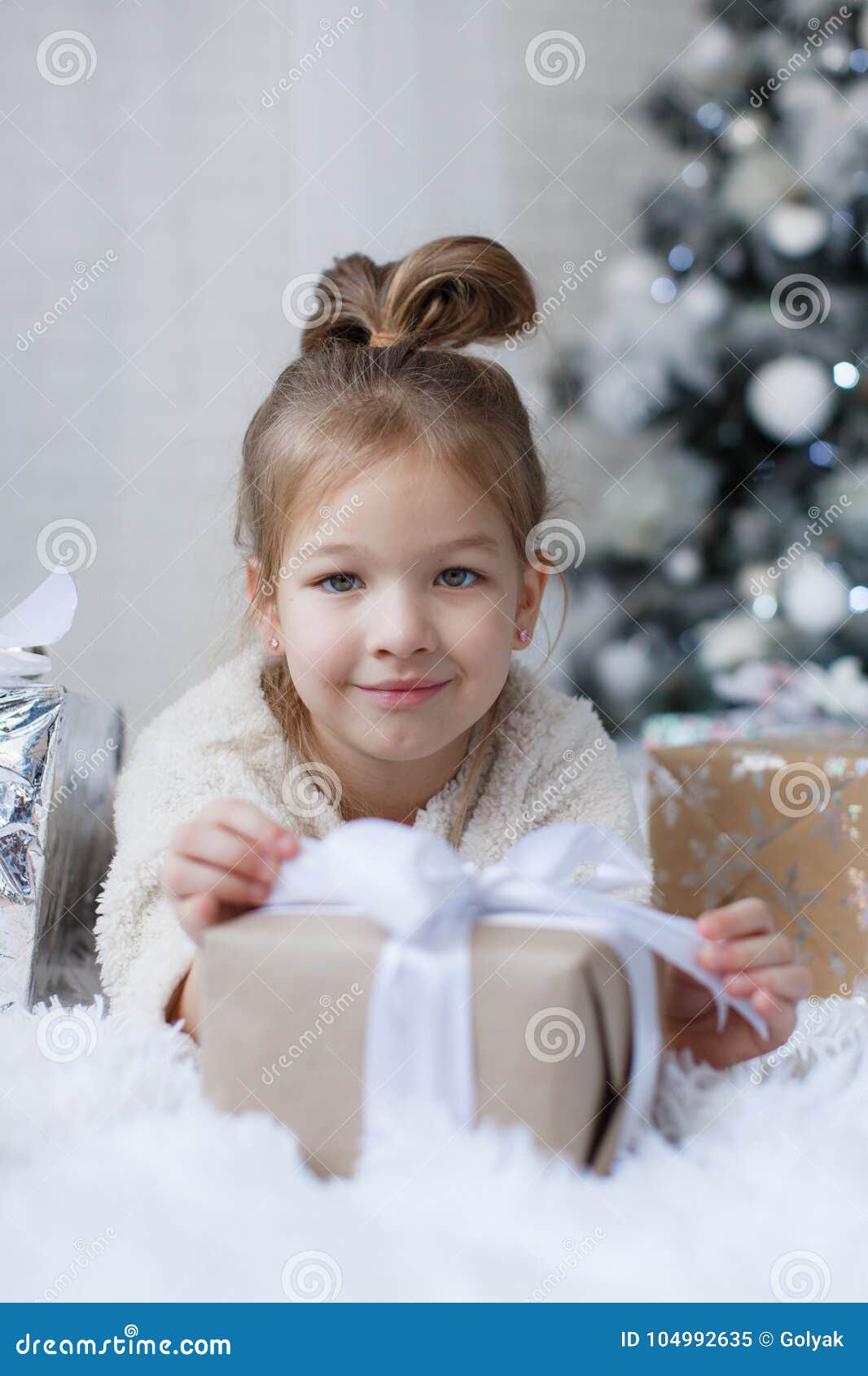 Little Girl Sitting On The Floor Near The Christmas Tree