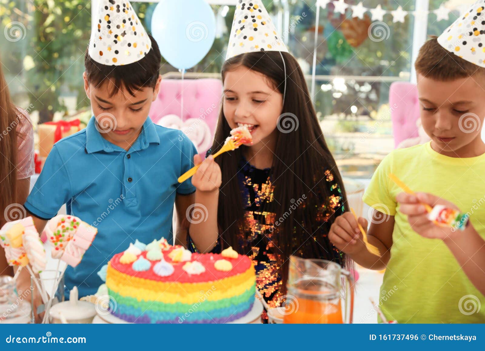 Happy Children Eating Delicious Cake at Birthday Party Stock Photo