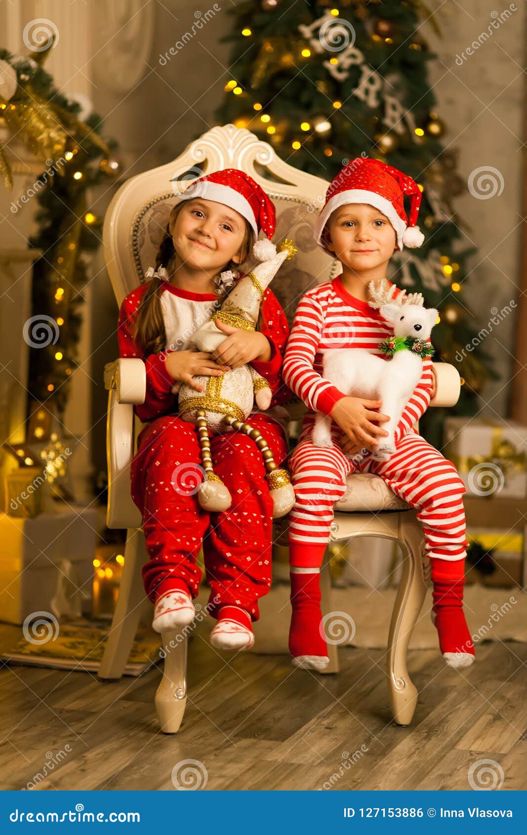 Happy Children Sit Together on a Chair Near the Christmas Tree Stock ...