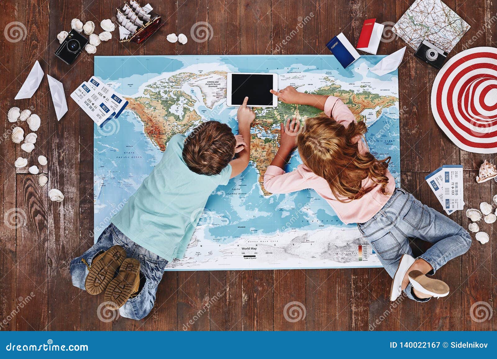 To Travel Is To Discover Children Lying On World Map Near Travel