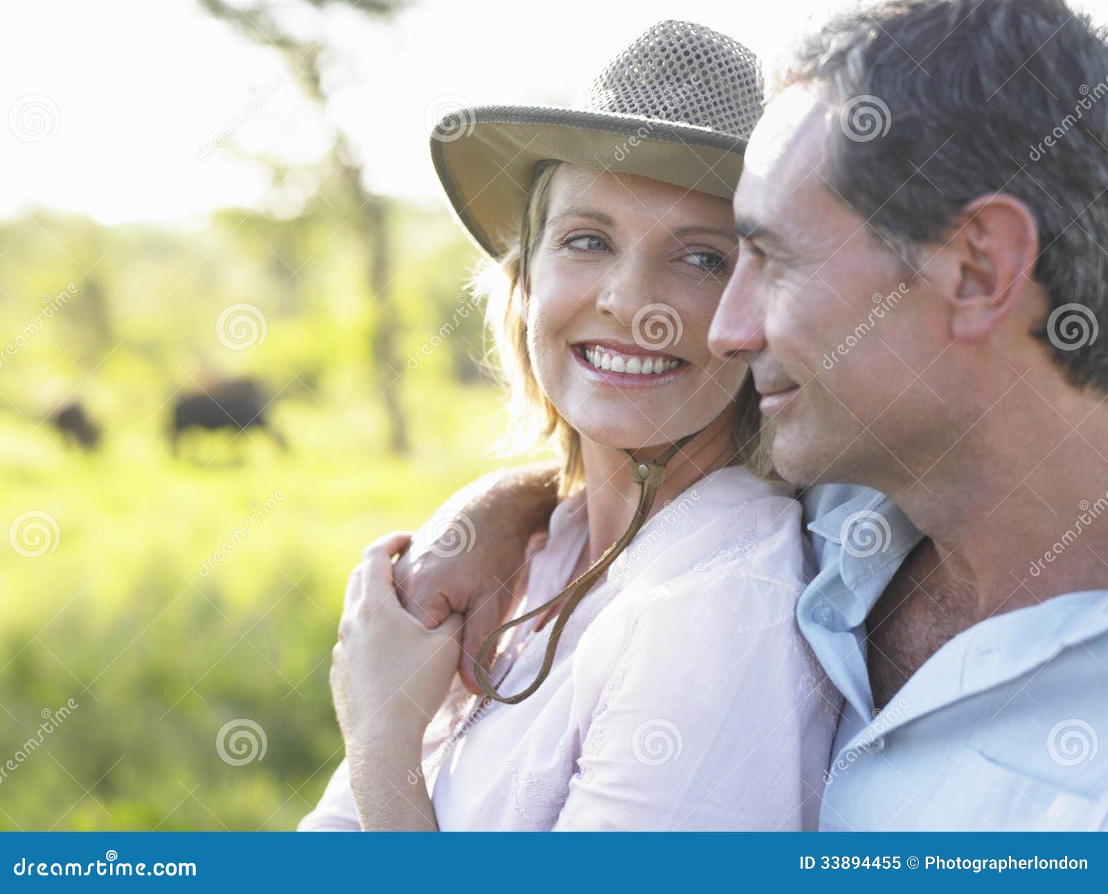 happy couple against blurred meadow