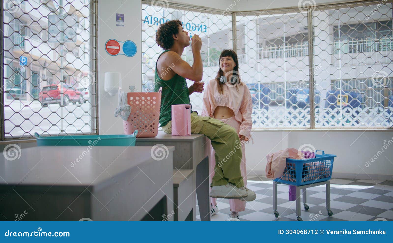 Happy Couple Blowing Bubbles in Laundromat Room. Cute Teenagers Washing ...