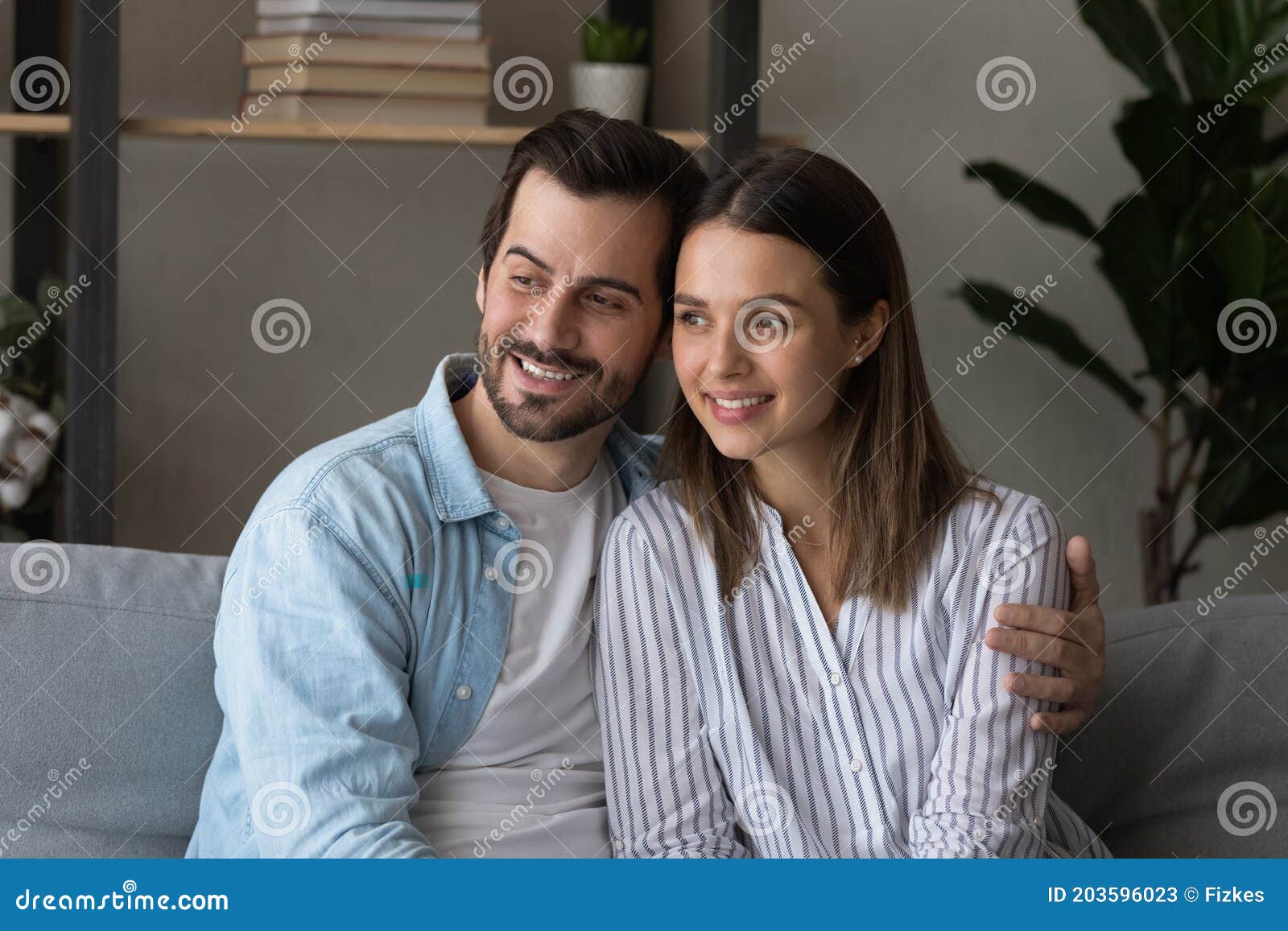 happy couple cuddle at home dreaming together