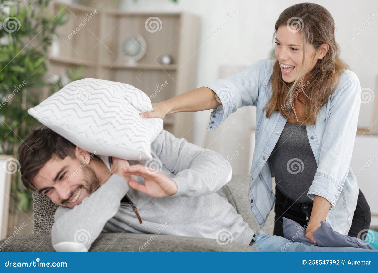 Happy Couple Doing Funny Pillow Fight Stock Photo Image of indoors