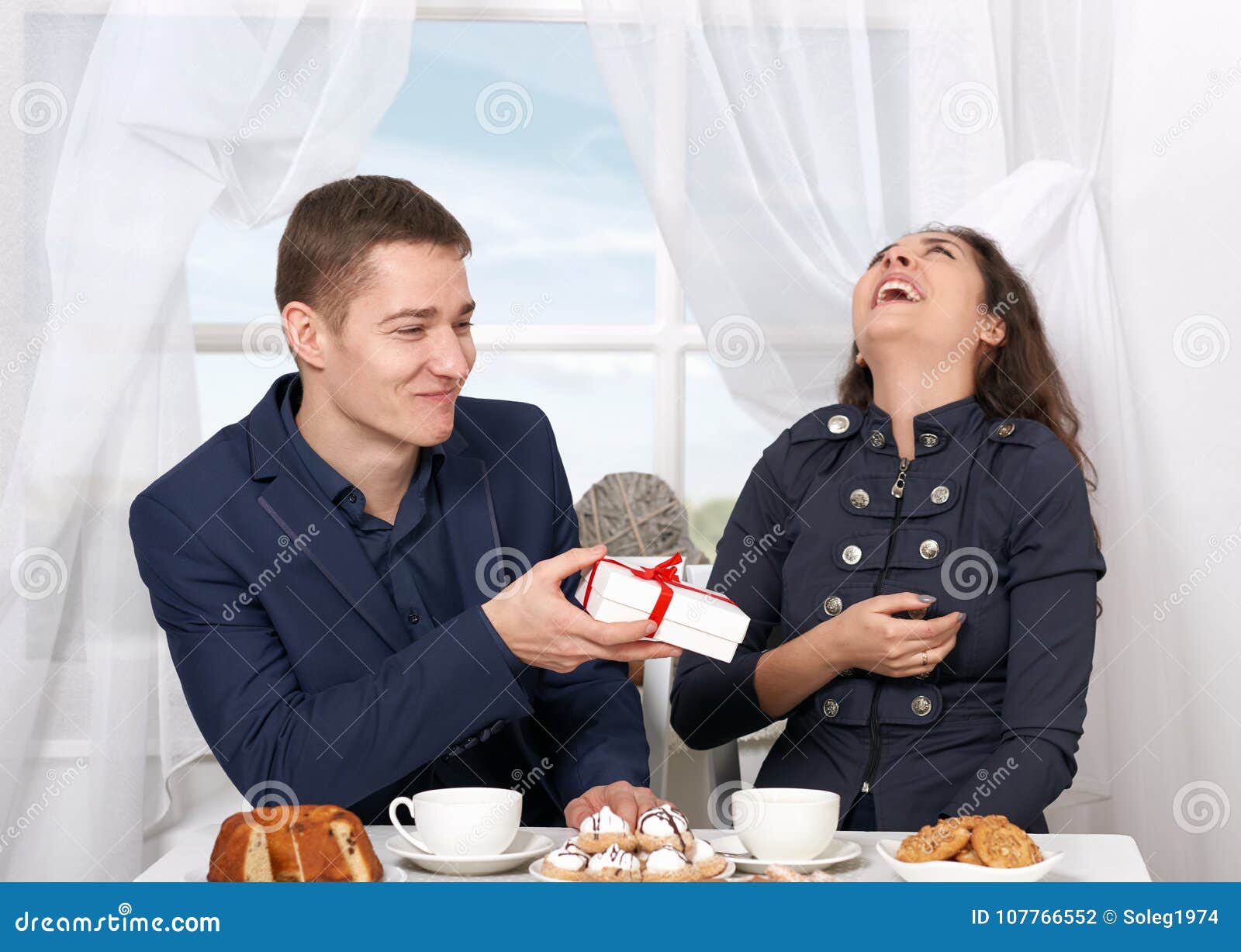 Happy Couple Drinking Coffee and Having Fun, Man Give Very Funny Gifts -  Love and Holiday Concept Stock Photo - Image of emotion, home: 107766552