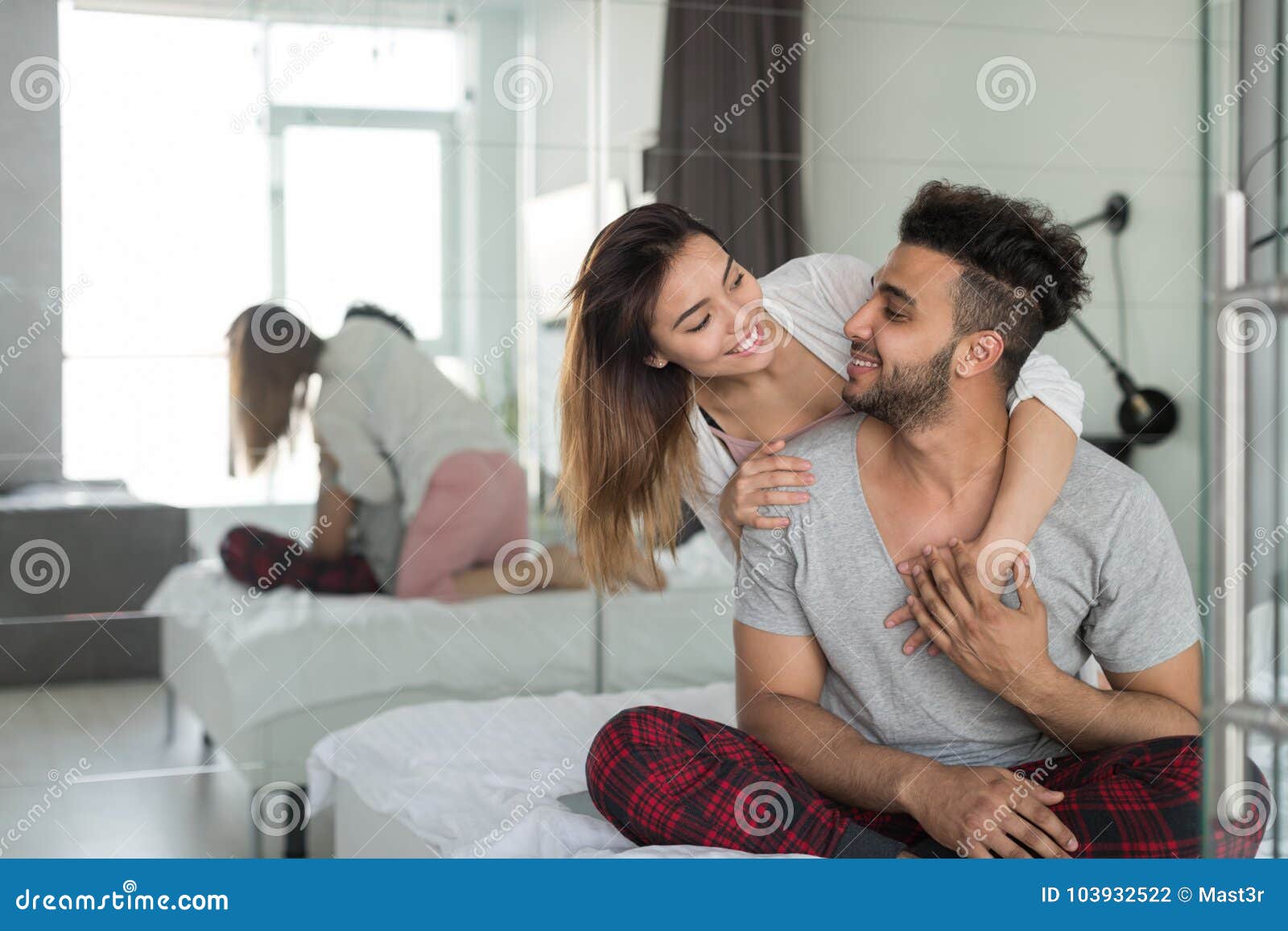 Happy Couple Embracing In Bed Young Man And Woman Smiling Sit