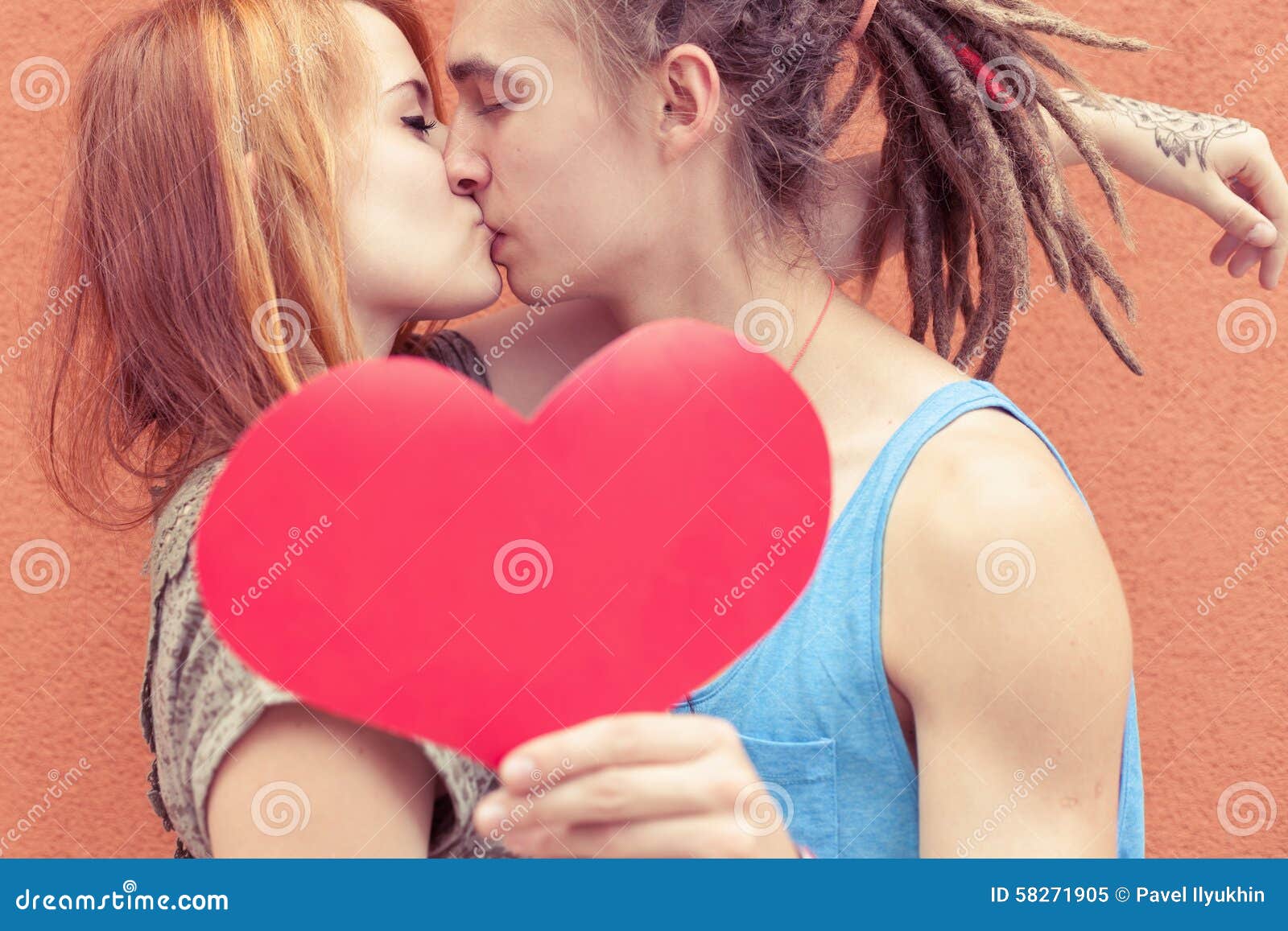 Happy Couple Kissing and Holding Heart at Red Wall Background ...