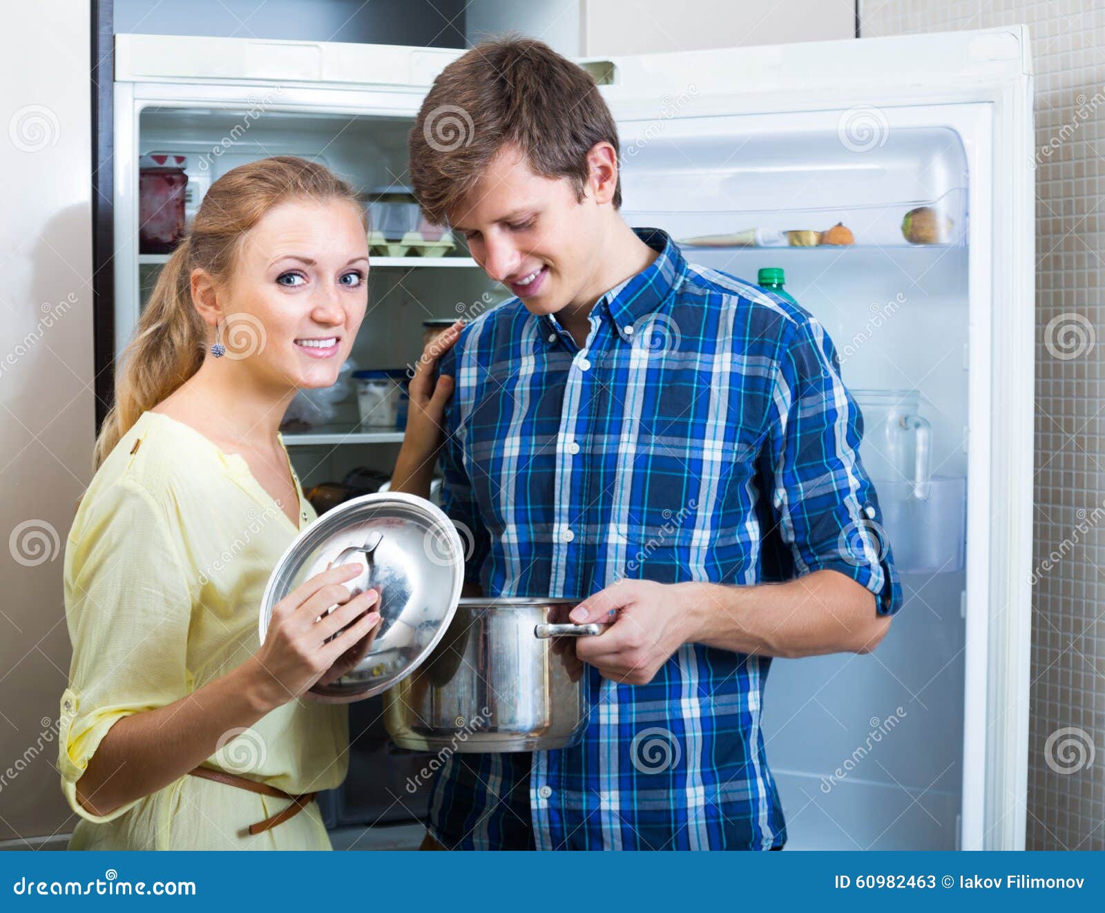 happy couple looking food near fridge