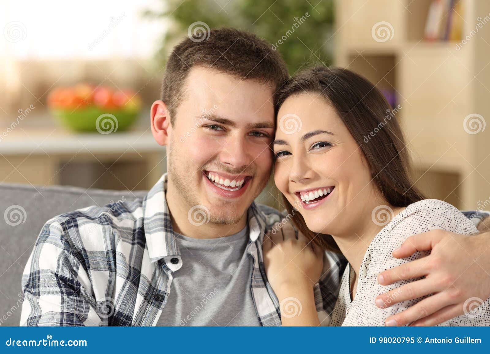 https://thumbs.dreamstime.com/z/happy-couple-perfect-teeth-looking-camera-sitting-couch-home-98020795.jpg