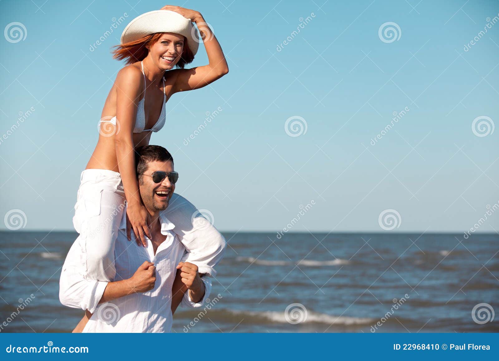 Lovely gay couple on piggyback ride at the beach. Stock Photo