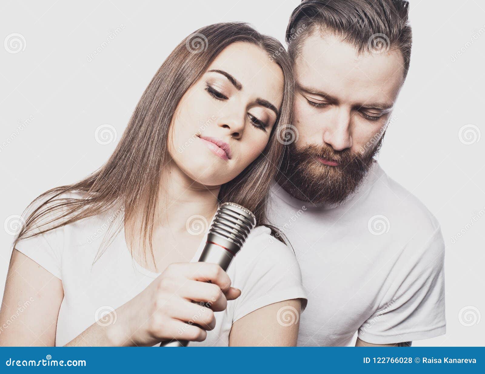 Happy Young Couple Singing in Karaoke Over White Background, Stock