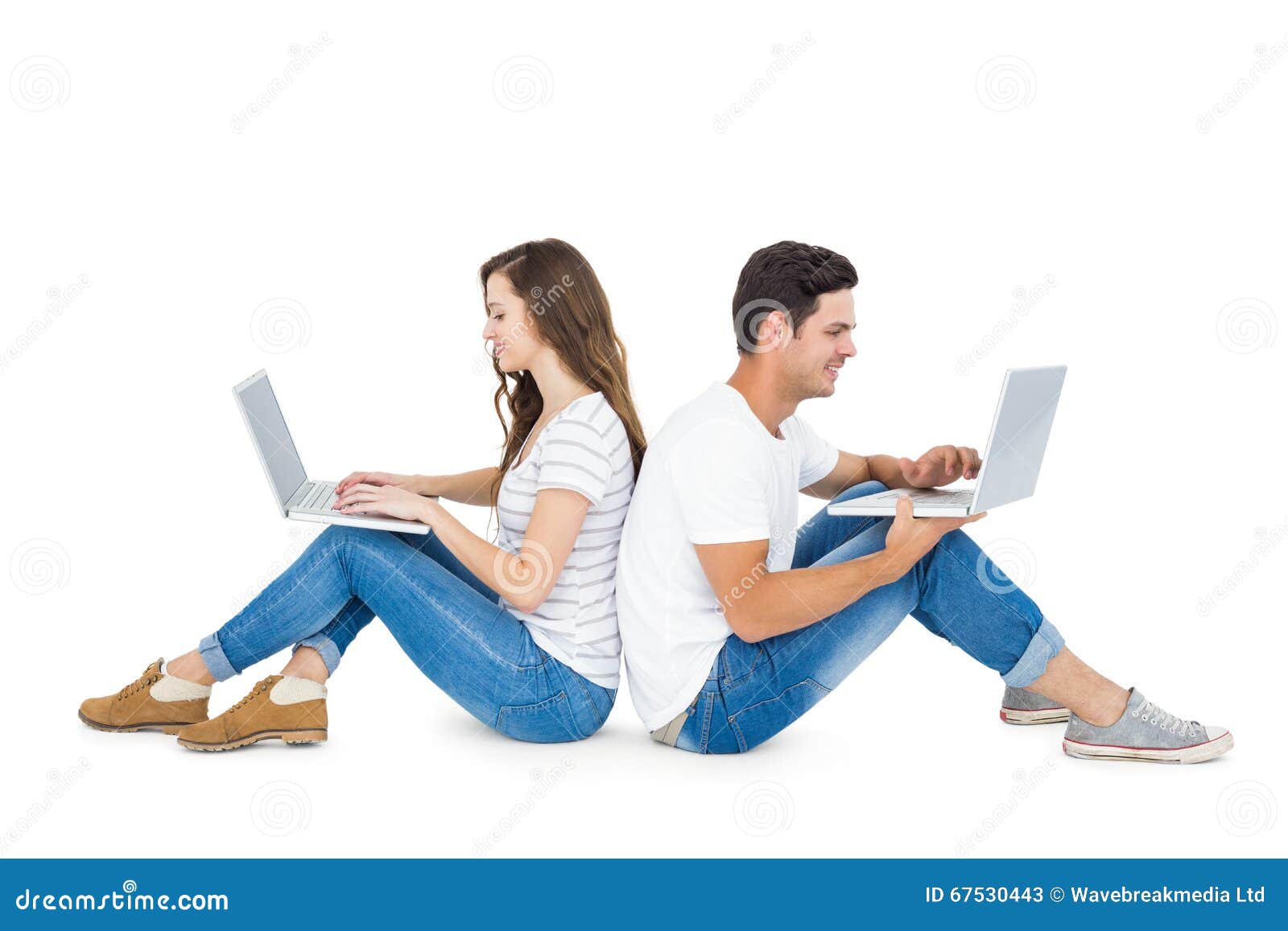 Happy Couple Sitting On The Floor Back To Back Using Laptop Stock Image