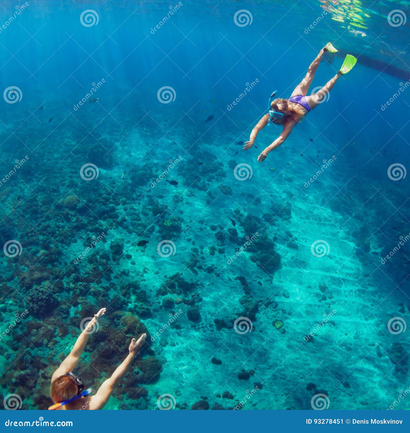 happy couple snorkeling underwater over coral reef