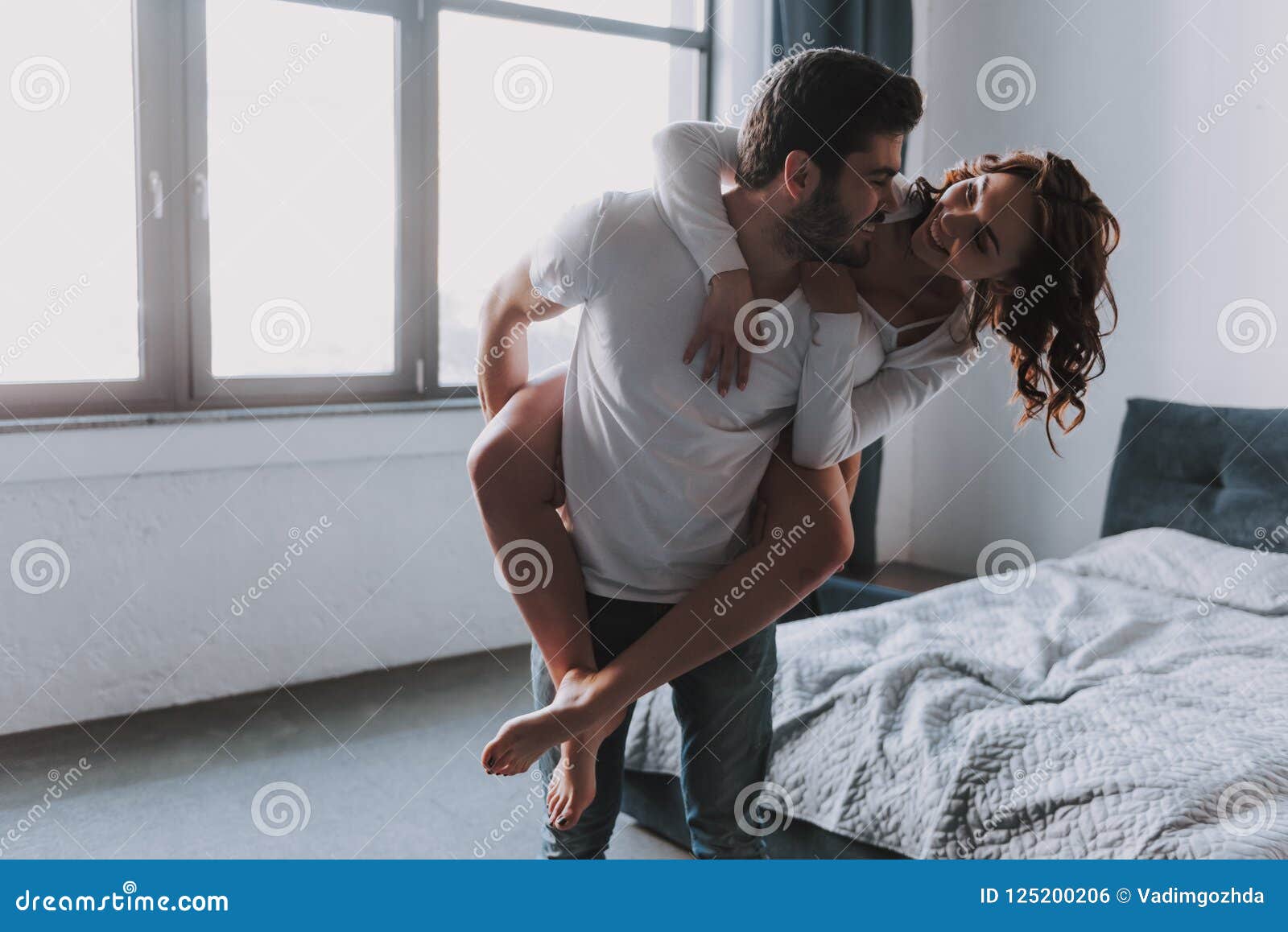 Happy Couple Together Having Fun in Bedroom Stock Photo