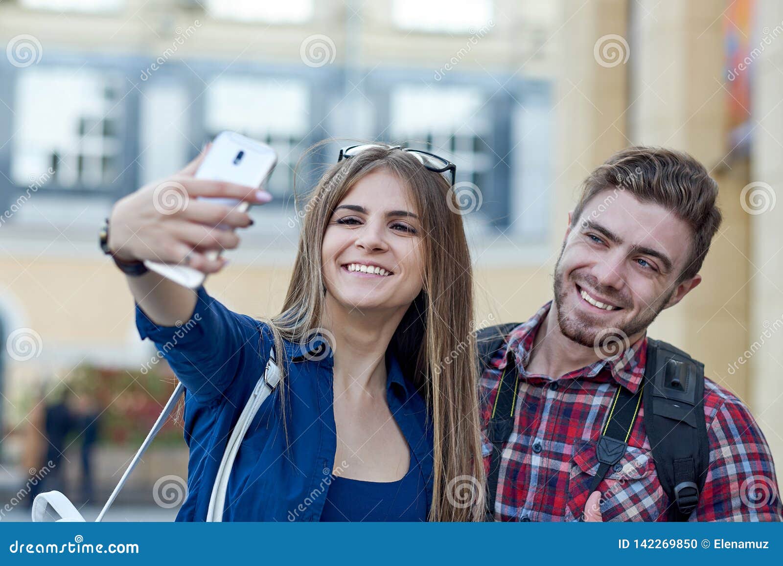 happy couple of tourists taking selfie in showplace of city