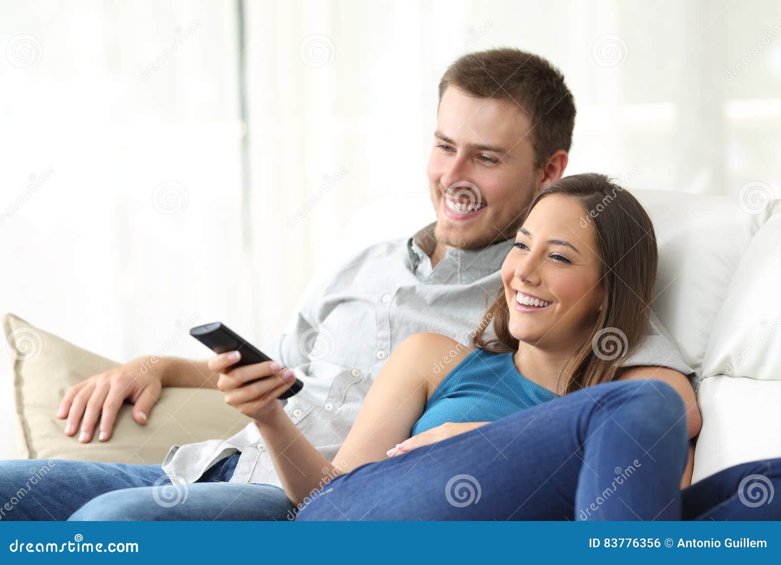 happy couple watching tv at home