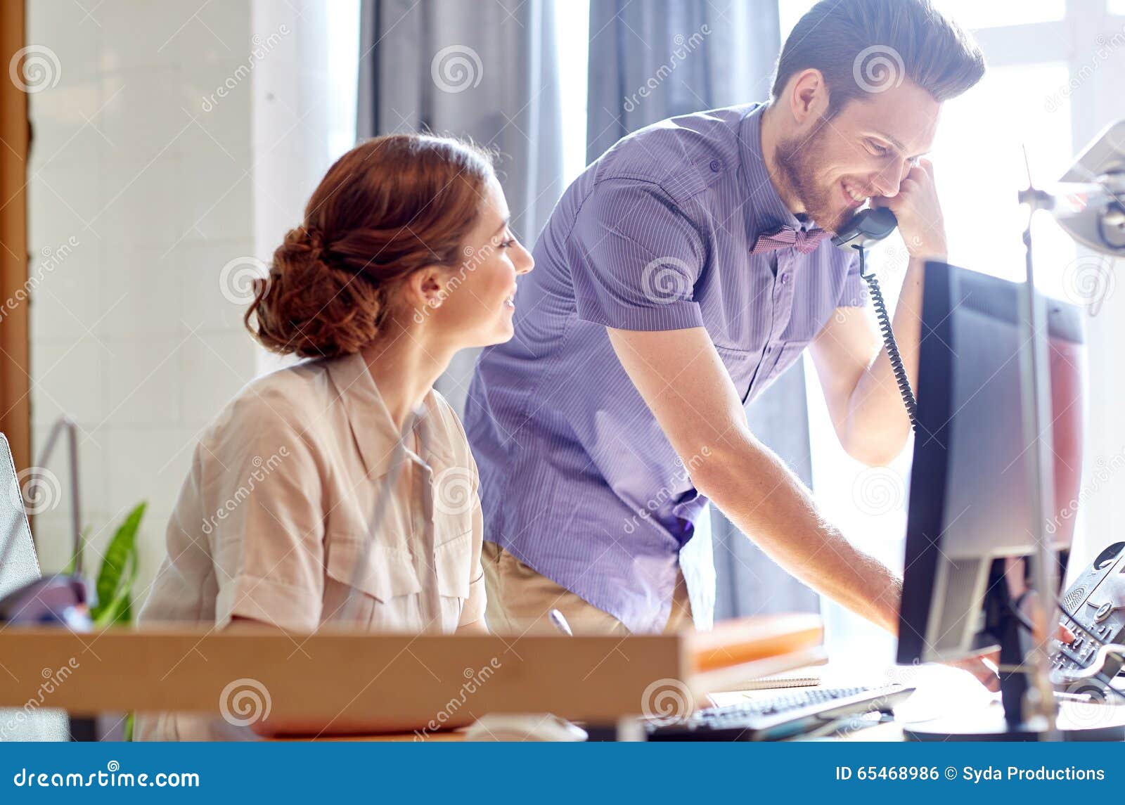 happy creative team calling on phone in office