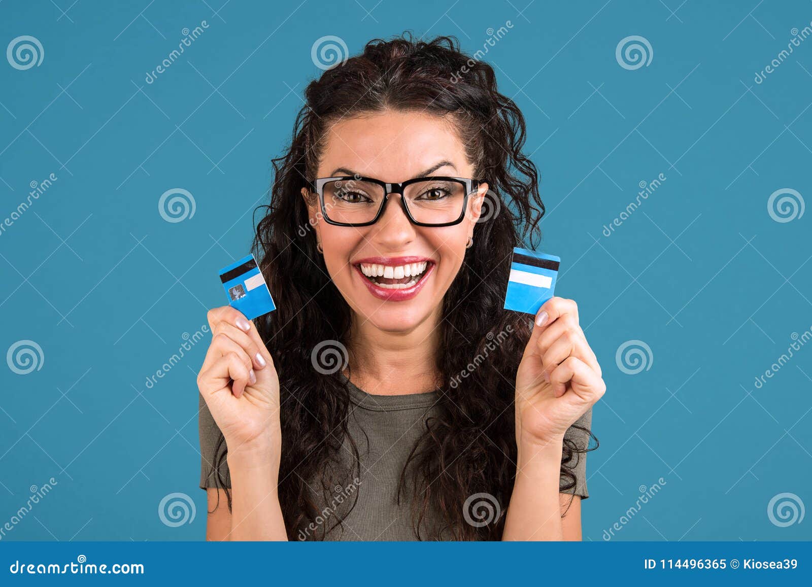 happy debt free woman holding a credit card cut in two pieces