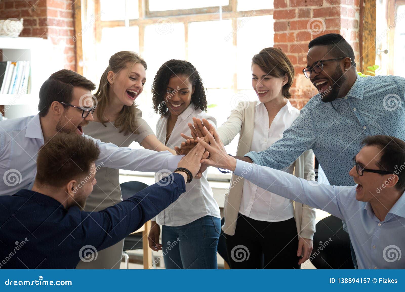 happy diverse colleagues give high five together celebrate great teamwork