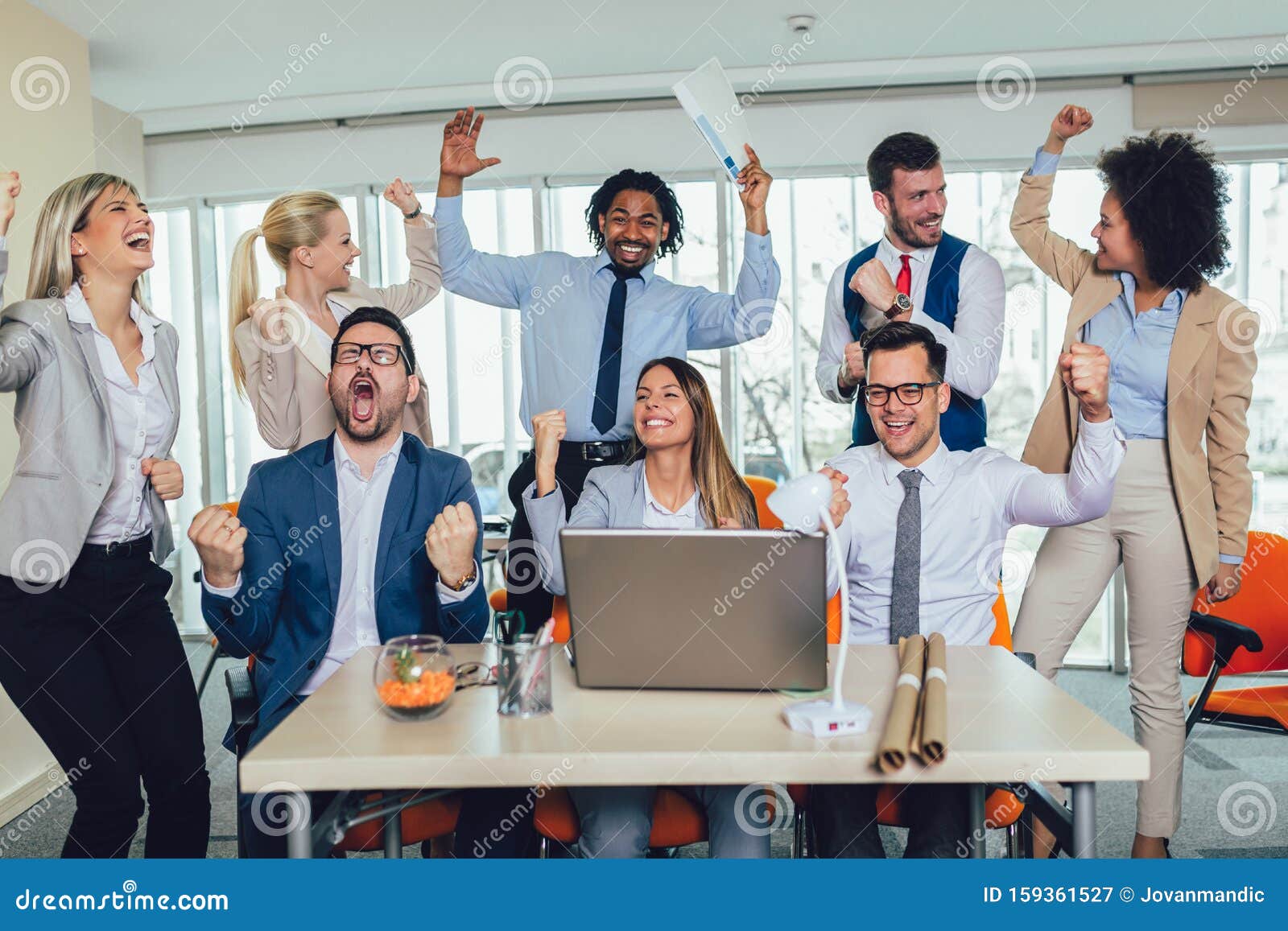 happy-diverse-male-female-business-people-formal-gathered-around-laptop-computer-group-bright-office-159361527.jpg