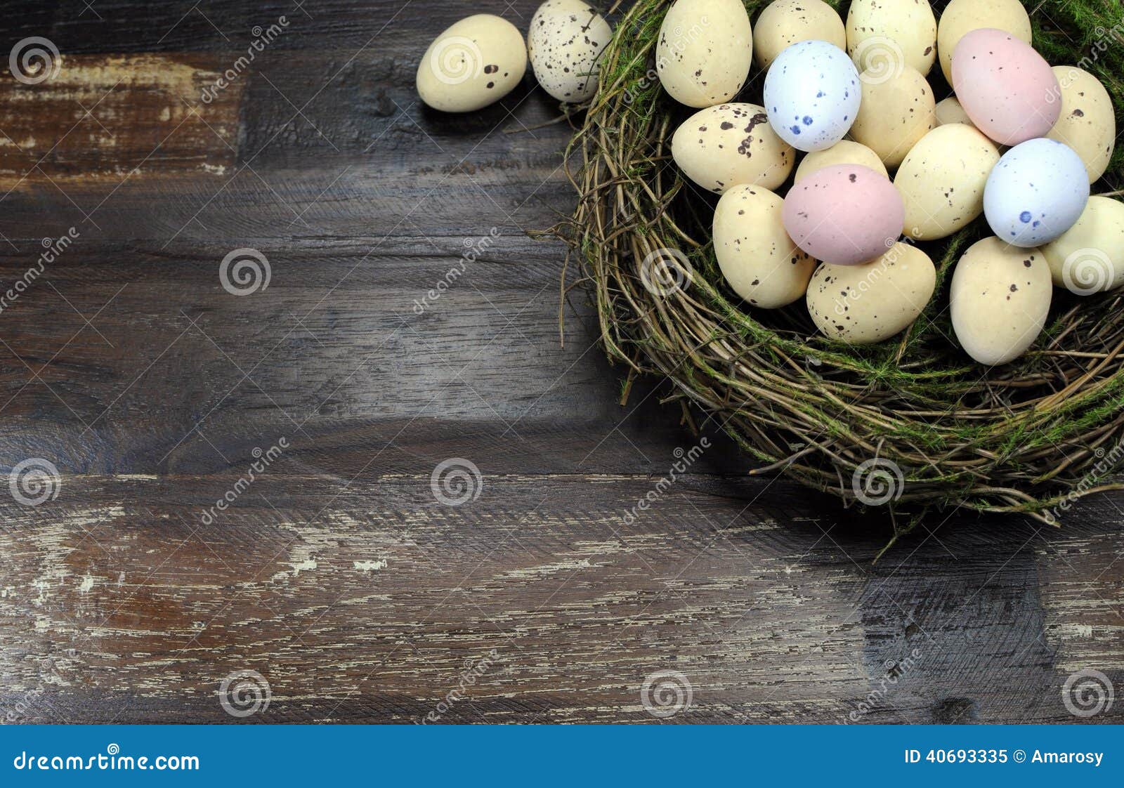 Happy Easter candy easter eggs in birds nest with copy space. Happy Easter candy easter eggs in birds nest on dark vintage recycled wood background with copy space for your text here.