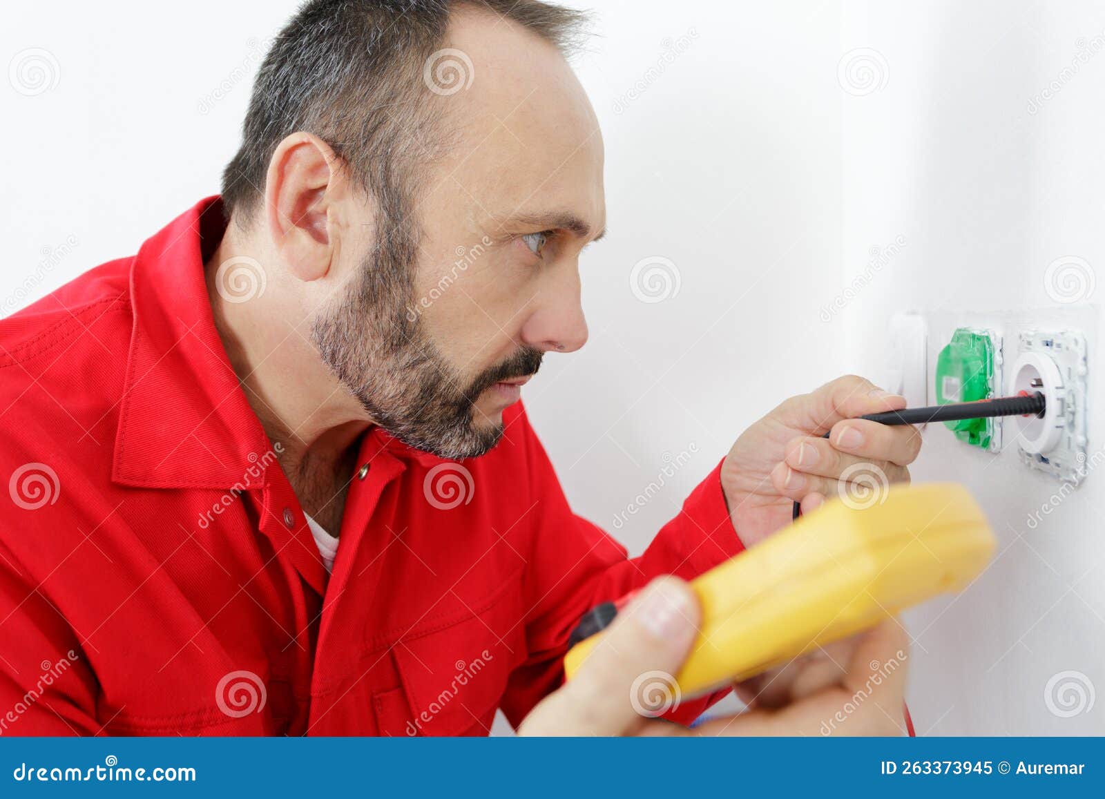 Happy Electrician Checking Voltage in Electrical Wall Socket Stock